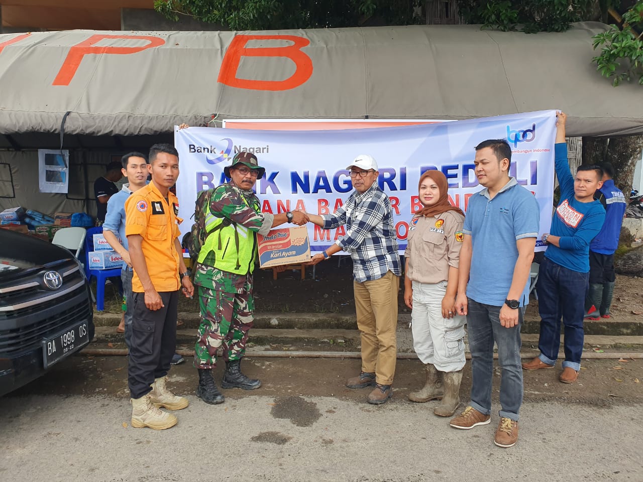 Kepala Cabang Bank Nagari Padang Panjang, Zulhendri (kanan) menyerahkan bantuan Bank Nagari peduli bagi korban bencana banjir bandang Malalo dan di terima Danramil Batipuh (kiri) di posko bencana setempat, Sabtu (18/1/2020).
