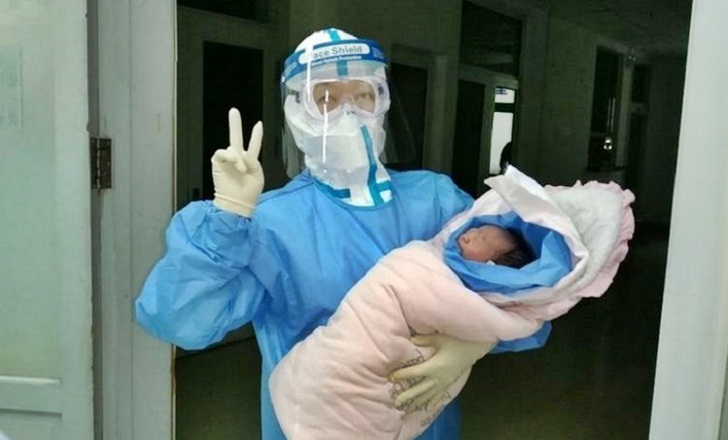 Ilustrasi: Dokter dari Rumah Sakit Nomor 6 Harbin, China, menggendong bayi yang lahir secara caesar dari ibu yang positif terkena virus corona. (CHINA DAILY/ASIA NEWS NETWORK via The Straits Times)
