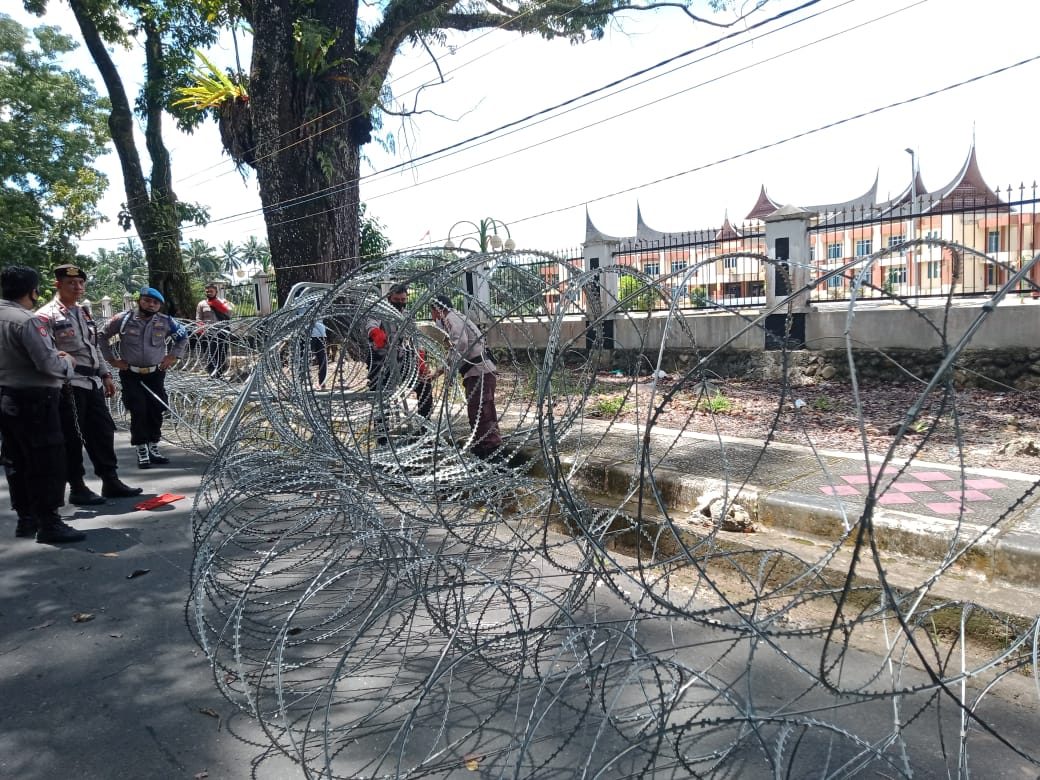 Aparat Kepolisian Sedang Pasangi Kawat Berduri di Depan Pintu Gerbang Kantor DPRD Pasaman Barat