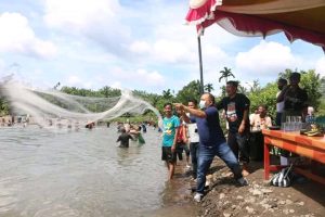 Bupati Pasaman Barat Hansastri Saat Melemparkan Alat Tradisional Yakni Jaring Ikan ke Sungai Batang Tupang, Kampuang Aua, Kecamatan Kinali, Minggu (01/11/2020) (ist)
